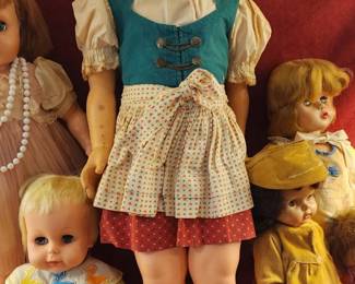 Vintage composition dolls dressed in colorful, period-style outfits