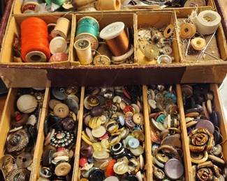 vintage sewing box filled with assorted spools of colorful thread and an extensive collection of decorative buttons