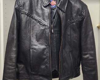 Vintage black leather motorcycle jacket with a zippered front, braided shoulder straps, and a satin lining