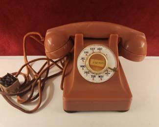 Vintage rotary dial telephone in a reddish-brown color