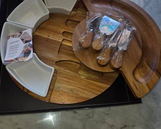 Slide Open Cheese Board with Condiment & Cracker containers & Utensils that fit inside.  Folds back to a Round Server