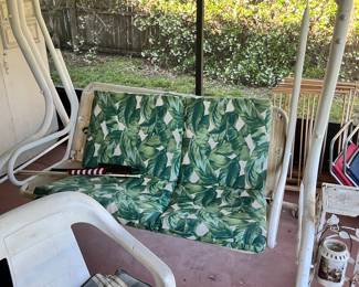 White Metal Two-Seater Porch Swing with Tropical Leaf Cushions