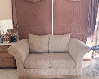 Transitional Loveseat with Rolled Arms and Carved Wood Base