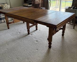 4' Oak table with 4 self-storing pop up 11" leaves. 
