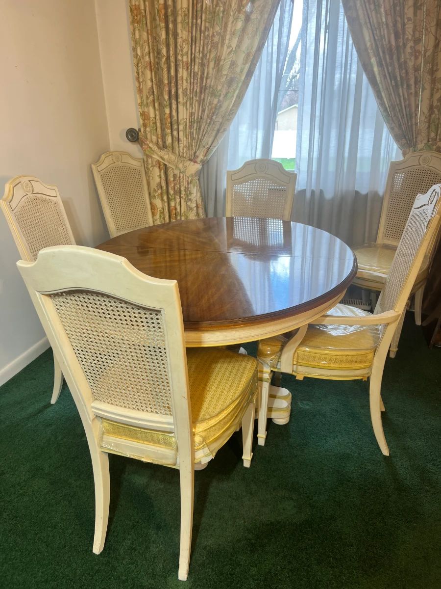 A mid-century bamboo and glass-top dinette with teal seating, and a formal cream French Provincial suite with six caned-back "sheaf" chairs