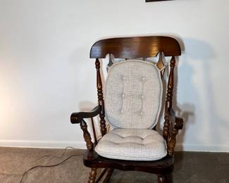 Stately dark wood rocking chair featuring a neutral-toned padded seat and back