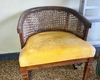 Classic wood armchair with a cane back and vibrant yellow velvet upholstered seat