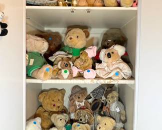A multi-shelf display of adorable plush bears and animals, many in vintage outfits