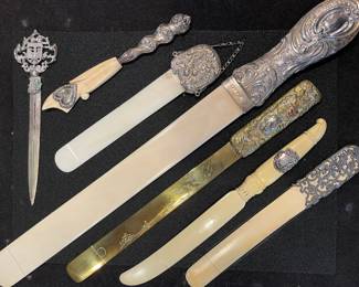 An exceptional collection of antique letter openers and page turners featuring sterling silver handles, carved bone, and etched brass blades