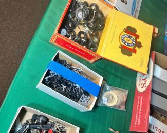 Boxes filled with vintage metal axles and rubber tires for model restoration