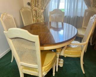 A mid-century bamboo and glass-top dinette with teal seating, and a formal cream French Provincial suite with six caned-back "sheaf" chairs