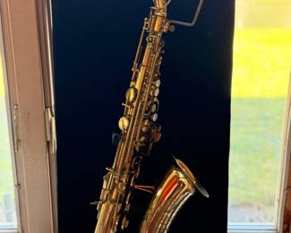 Vintage Buescher 140 Aristocrat Series III Alto Saxaphone on a display stand.  The original case will be included but is not photographed