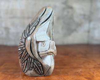 This lot features an original soapstone sculpture that’s believed to be by listed Cree artist, Howard Moose. Minor chipping throughout shown in photos and signed by Howard underneath. This sculpture measures, 9” H x 5.5” W x 5.5” D. Born in 1966, Moose began carving at age eight and transitioned from wood to stone mediums like soapstone and alabaster.