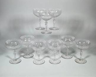 (2pc) LLADRÓ (SPAIN) GIRL WITH DOG AND GEESE PORCELAIN FIGURES | Set of nine clear cut crystal coupe glasses. Each glass has a shallow bowl with a repeating floral/leaf engraved pattern, a twisted (air-style) stem with a small knop, and a round flat base with circular polished indentations
