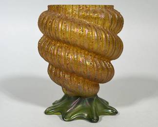 OPALESCENT SPIRAL ART GLASS VASE WITH RUFFLED GREEN BASE | Gold-opalescent glass vase with a pronounced spiral, ribbed body and a pitted/sandy surface texture showing an overall iridescent (aurene-like) sheen. The body sits on a green, ruffled star-shaped/ruffled base that also displays iridescence. The rim is polished and the exterior shows clearly defined molded or applied ribs forming a corkscrew profile. 