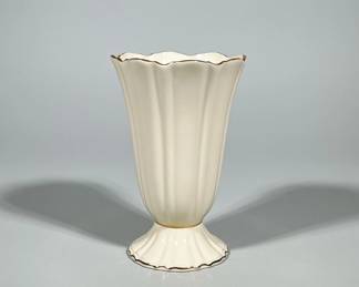 LENOX PORCELAIN FLUTED VASE WITH GILT RIM | Ivory/cream glazed porcelain vase with a fluted, trumpet-shaped body, scalloped rim and scalloped circular foot. Gilt trim applied to the rim, the junction of foot and body, and the foot edge. Interior base bears a printed LENOX mark with wreath and "Made in USA." 
