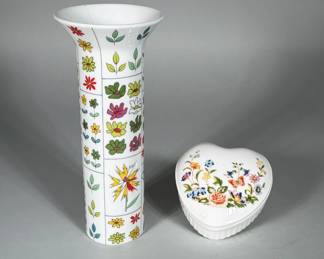 (2pc) ROSENTHAL STUDIO-LINE 'PUCCI' PORCELAIN VASE (DESIGN: BAUMANN/PUCCI) AND AYNSLEY 'COTTAGE GARDEN' HEART COVERED DISH | Lot of two porcelain items: a Rosenthal Studio-Line trumpet vase decorated in vertical paneled stylized floral motifs in green, yellow, pink and red, and an Aynsley heart-shaped covered trinket dish with a polychrome cottage-garden floral spray on the lid. Vase base bears a green Rosenthal Germany mark with printed text "studio-line: berlin design: Baumann Pucci" and a script signature; h. 9.25 in., diam. 4 in. Aynsley dish base bears a blue Aynsley mark with the pattern name "Cottage Garden" and "Made in England" transfer. Both items are white-glazed porcelain/bone china with transfer and enamel decoration visible on the surfaces.