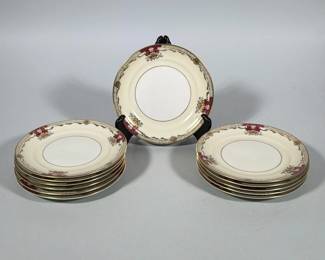 (12pc) MEITO CHINA SAVONA IVORY CHINA BREAD AND BUTTER PLATES | Group of ivory-colored bread and butter plates with a wide rim decorated with gilt foliate motifs, a narrow gilt inner band, and magenta cartouche accents at intervals around the border. Gilded edge and gilt floral ornamentation decorate the rim with a finely detailed gilt lattice band near the rim. Backstamp on the underside reads "EMPIRE SHAPE MEITO CHINA SAVONA Ivory China" and an additional small mark reads "Made in Occupied Japan." 