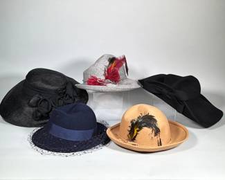 (5pc) GROUP OF FIVE VINTAGE WOMEN'S HATS, FELT AND STRAW | Group of five vintage women's hats in felt and straw construction in black, navy, grey and tan. Embellishments include feathers, a netted veil, self-fabric bows and rosette trim; the tan felt bowler is trimmed with a multicolored feather spray.