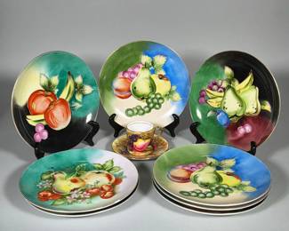 (10pc) AYNSLEY ENGLAND HAND-PAINTED FRUIT SALAD PLATES WITH DEMITASSE CUP & SAUCER | Group of hand-painted Aynsley bone china comprising multiple fruit-motif salad plates and one demitasse cup with matching saucer. Plates and cup feature polychrome fruit decoration with gilt rims; one plate underside is marked “Hand Painted.” Cup base stamped with Aynsley crown backstamp reading “AYNSLEY ENGLAND BONE CHINA,” hand-numbered 27 and inscribed in red “1930.” One salad dish measures diameter 8.25 in.