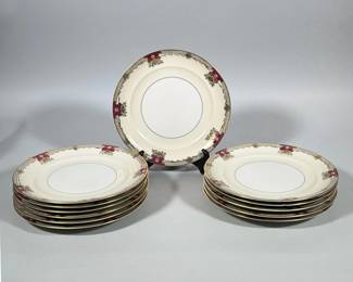 (12pc) NORITAKE SAVONA IVORY PORCELAIN DINNER PLATES | Ivory porcelain dinner plates with a white recessed center and a narrow gilt inner band. Rims feature gilt floral scrollwork, a fine engine-turned style ground border, and magenta cartouche accents placed at regular intervals; edges finished with gilt. Decoration shows raised gilt highlights and delicate line work in the border. 