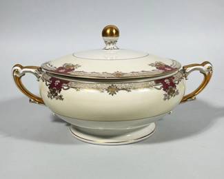 MEITO CHINA 'SAVONA' IVORY CHINA COVERED TUREEN | Cream-colored porcelain covered tureen with two scrolled handles and a domed lid topped by a gilt knob. Decorated with magenta cartouche accents, gilt floral and foliate border work, and gilt trim on handles, rim, finial, and foot. Green backstamp on the base reads "EMPIRE SHAPE MEITO CHINA SAVONA" with red script "Ivory China" and additional script "Made in Occupied Japan."