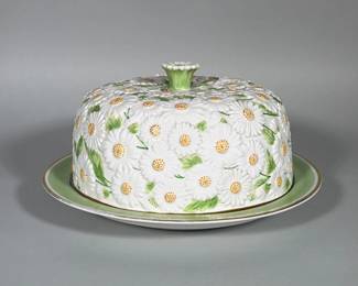 ITALIAN PORCELAIN DAISY COVERED CAKE PLATE, HAND-PAINTED | Covered porcelain cake plate molded overall with raised daisy motifs and hand-painted yellow centers and green leaves; domed cover with a flower-form knob. Plate interior and rim are glazed celadon green with a gilded band at the inner rim. Underside bears a gilt hand-painted mark reading "ITALY" and a number. White glazed porcelain body with all-over applied floral relief decoration.