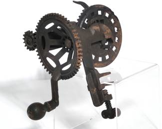 C. E. HUDSON (LEOMINSTER, MASS.) CAST-IRON TABLE-MOUNT APPLE PEELER | Cast-iron table-mount apple peeler with geared crank mechanism. Features two large meshing spur gears driving a smaller pinion, a fork/prong for holding fruit, a spring-loaded lever assembly with blade, and a screw clamp for mounting to a table edge. Surface shows uniform dark oxidation/rust and light pitting; wooden knob with paint wear and age-related abrasions.