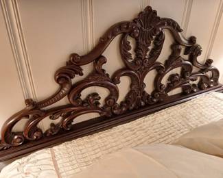 The carved headboard is attached to the wall