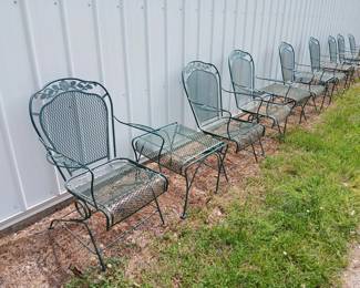 Eight wrought iron spring type rocking chairs and five side tables