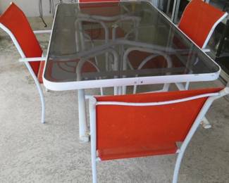 Glass Top Patio Table with Orange Sling Chairs