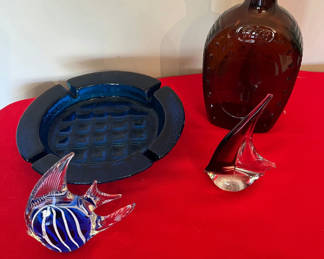 Lot 131: Glass art pieces including blue striped fish, blue ashtray, brown sailboat, brown bottle, and blue ashtray