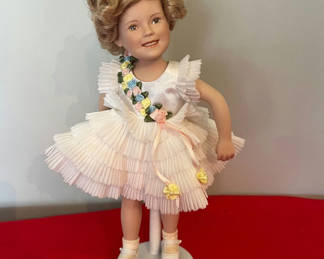 Lot 140: Shirley Temple Doll with White Pleated Dress and Floral Sash