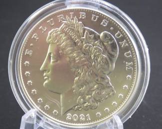 Lot 183. Uncirculated very high grade and encapsulated 2021 P Morgan Silver Dollar with 99.9% silver, a silver weight of .858 of a troy ounce, and a certificate of authenticity from the US Mint