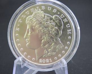 Lot 184. Uncirculated very high grade and encapsulated 2021 D Morgan Silver Dollar with 99.9% silver, a silver weight of .858 of a troy ounce, and a certificate of authenticity from the US Mint