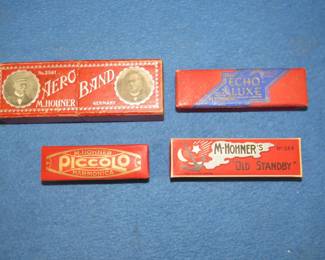 Lot 104. Four vintage empty harmonica boxes in excellent condition: Two-piece Hohner Aero Band No. 2561. M. Hohner Old Standby No. 34B hinged box. M. Hohner Piccolo hinged box. M. Hohner Echo Luxe hinged box.