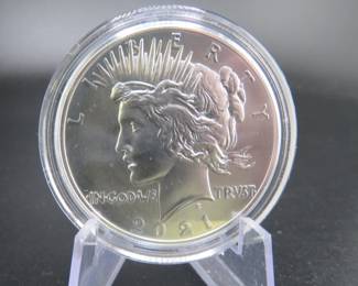 Lot 180. Uncirculated very high grade and encapsulated 2021 P Peace Silver Dollar with 99.9% silver, a silver weight of .858 of a troy ounce, and a certificate of authenticity from the US Mint