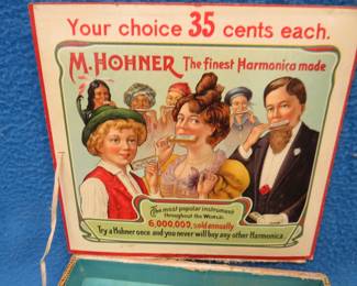 Lot 282. Two display boxes. A Hohner with a detached lid and a Cutco