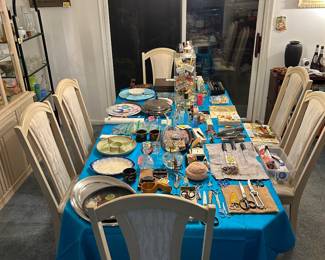 Dining room table and chairs as well as a china cabinet and hutch, but also MANY things displayed on table! 