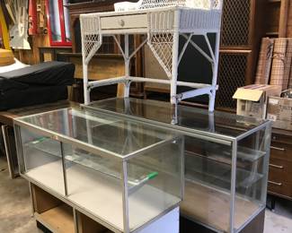Two glass display cases and wicker desk