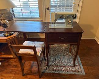 Universal Antique sewing machine is great condition.  Comes with the additional chair and the attachments for the machine