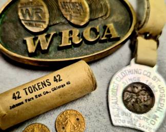 "St. Joseph Light and Power Reddy Kilowatt" roll of bus tokens, "A. J. August Clothing" good luck token and "WRCA" Wire Rope belt buckle 