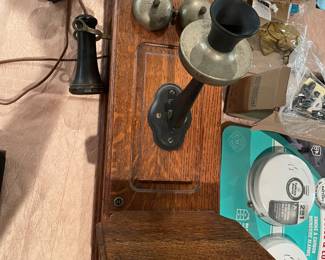Antique Wall Crank Telephone – Solid Oak – Early 1900s Style: Beautiful antique wall-mounted crank telephone featuring a solid oak wood cabinet and classic early 1900s design.  This piece includes the original-style metal mouthpiece, separate earpiece receiver, and hand crank—giving it that authentic vintage character collectors and decorators look for. These early wall telephones were commonly used from the late 1800s through the early 1900s and are now highly sought after as statement décor pieces.  The wood grain on this one is especially rich, and the overall construction is solid and well-preserved. 