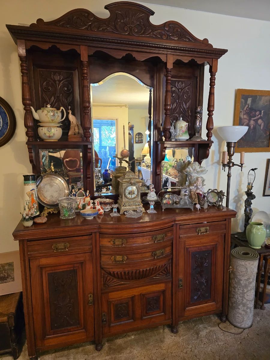 Antique hand carved bow front hutch; antique metal clock; porcelain collectibles