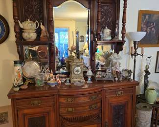 Antique hand carved bow front hutch; antique metal clock; porcelain collectibles