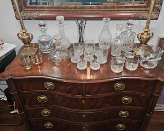 Various decanters and glass ware on chest of drawers