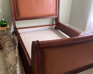 Sleigh bed with leather headboard. Beautiful large rug rolled up.