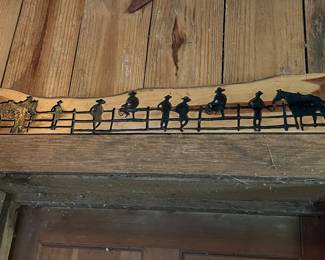 Rustic Western-themed wood and metal wall art with cowboy and horse figures.