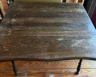 Antique dark wood drop-leaf table with turned legs.