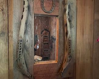 Handmade rustic mirror with horseshoe and reclaimed wood frame.